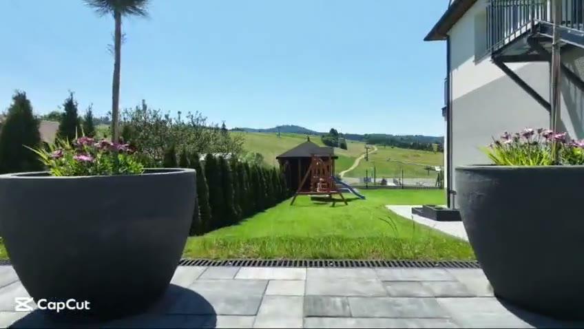 Film pokazujący plac zabaw i altankę przy budynku
