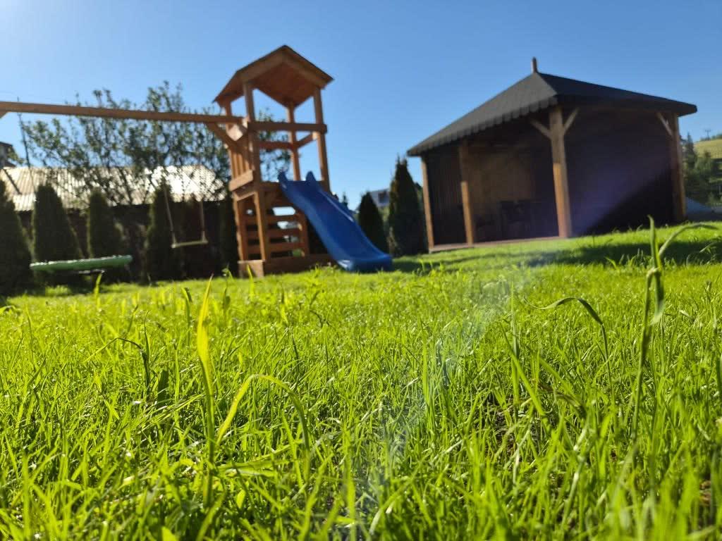 Plac zabaw z domkiem i zjeżdżalnią przy apartamentach